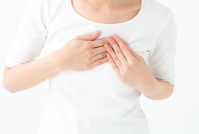 胸に手を当てる白い服の女性