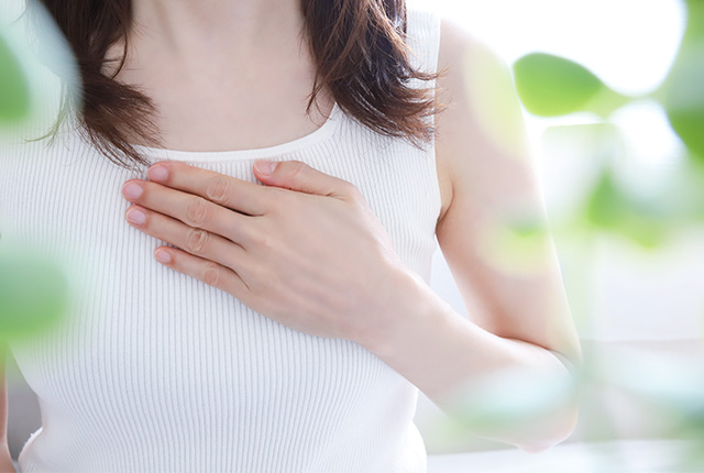胸に手を当てる女性